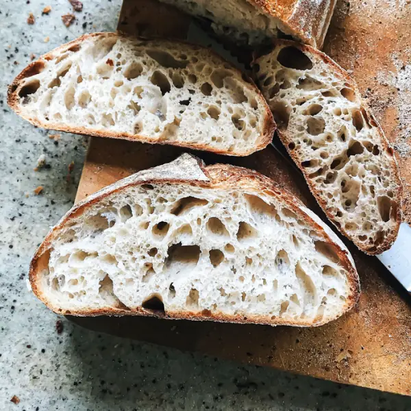 A sourdough loaf cut open to show its airy, open crumb